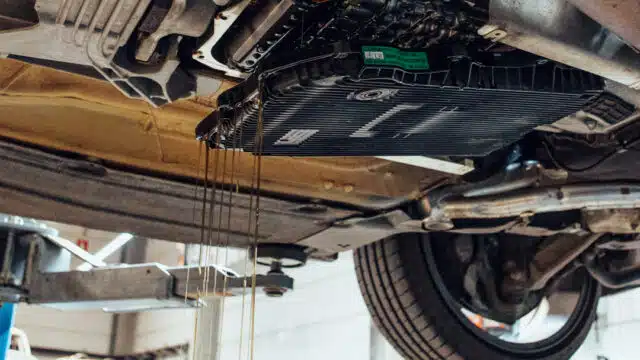Vidange boîte de vitesse BMW sur pont élévateur dans l'atelier Bavarian à Nivelles